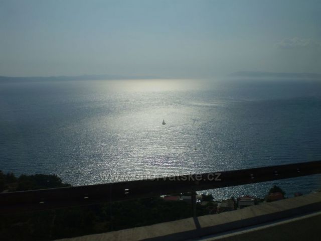 Snímek stříbromodrého Jadranu za jízdy autobusu po Jadranské magistrále